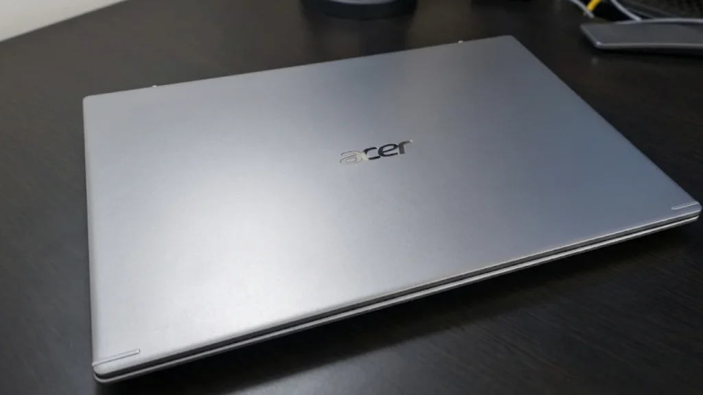 Top 10 Laptop Brands in 2026. A closed, minimalist silver Acer laptop resting on a dark desk surface.