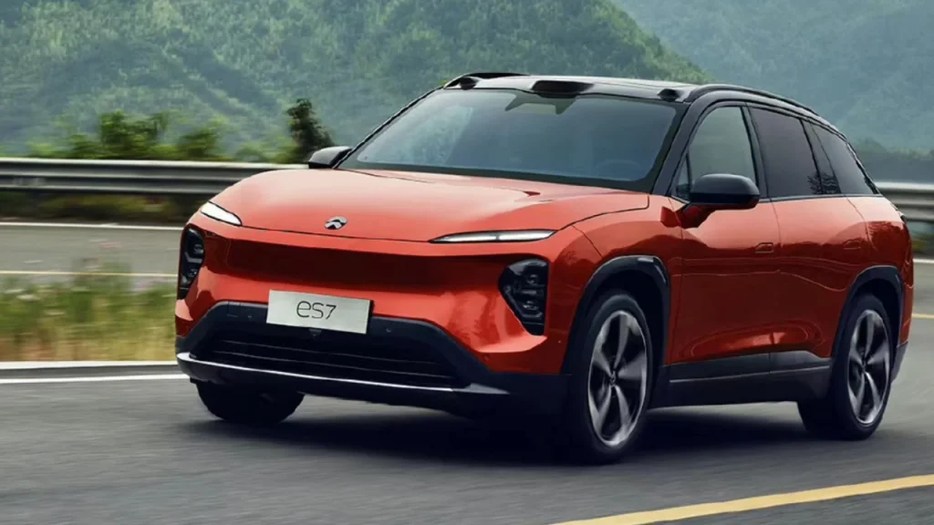 A bright orange Nio electric SUV navigating a coastal road, demonstrating innovation from the Best EV brands.