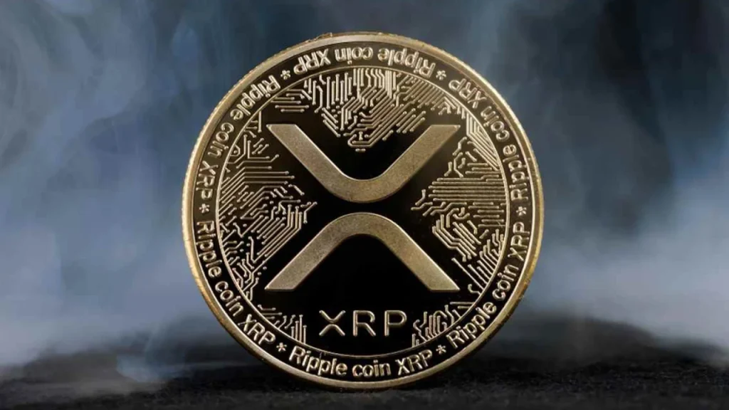Gold XRP (Ripple) coin with the X logo and circuit-board pattern, set against a smoky blue-gray background.